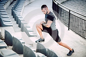 Man doing interval exercises, running and jogging on stadium stairs. Legs and fitness training