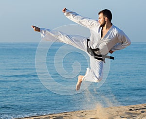 Man doing karate at ocean