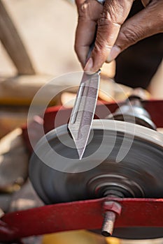 Man doing knife sharpen at iron sharpener from different angle
