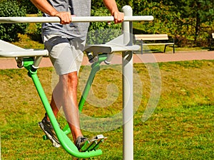 Man doing legs exercises in outdoor gym