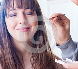 Man doing make-up for cute woman in beauty salon