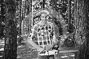 Man doing mans job. Happy Woodworkers lumberjack. Lumberjack with chainsaw on forest background. Agriculture and
