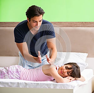 Man doing massage to his wife in bedroom