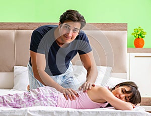 Man doing massage to his wife in bedroom