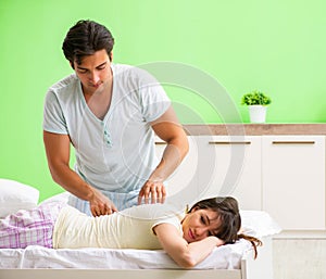 Man doing massage to his wife in bedroom