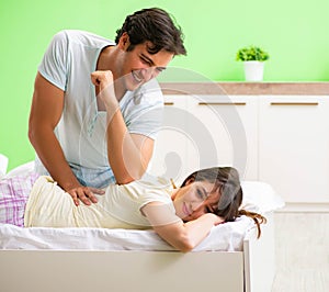 Man doing massage to his wife in bedroom