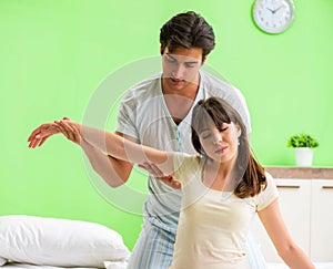 Man doing massage to his wife in bedroom