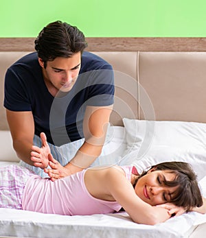 Man doing massage to his wife in bedroom