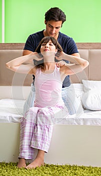 Man doing massage to his wife in bedroom