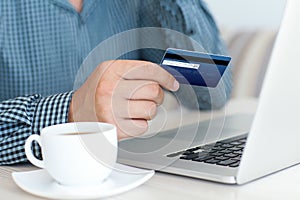 Man doing online shopping with credit card on laptop