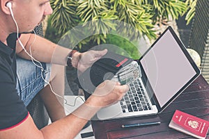 Man doing online shopping with credit card, laptop and luxury snakeskin python wallet. Man online shopping concept.