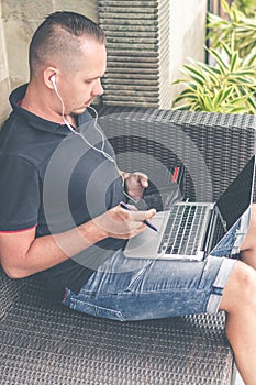 Man doing online shopping with credit card, laptop and luxury snakeskin python wallet. Man online shopping concept.