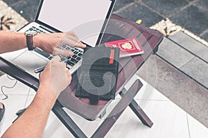 Man doing online shopping with credit card, laptop and luxury snakeskin python wallet. Man online shopping concept.