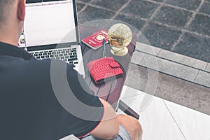 Man doing online shopping with laptop and luxury snakeskin python wallet. Man online shopping concept.