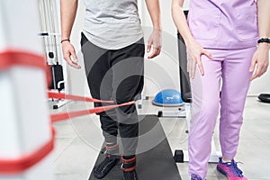 Man doing physical therapy exercise with elastic fitness rope