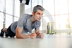 Man doing planking exercise in gym photo