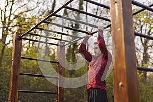 Man doing pull ups while doing an outdoor workout