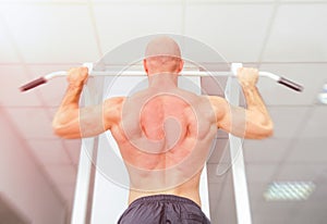 Man doing pull ups with well shaped muscles