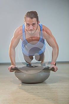 Man doing push-up on bosuball