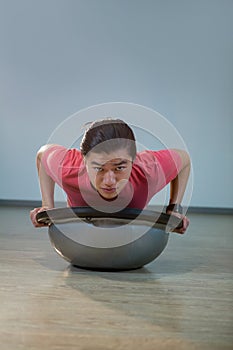 Man doing push-up on bosuball