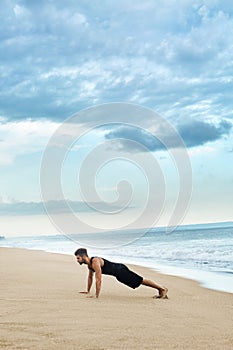 Man Doing Push Up Exercise On Beach. Body Exercising Concept