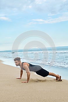 Man Doing Push Up Exercise On Beach. Body Exercising Concept