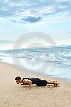 Man Doing Push Up Exercise On Beach. Body Exercising Concept