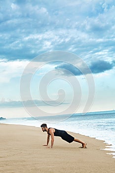 Man Doing Push Up Exercise On Beach. Body Exercising Concept