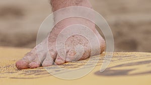 Man doing a push-up exercise on beach sand mat