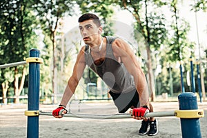 Man doing push-up exercise using horizontal bar