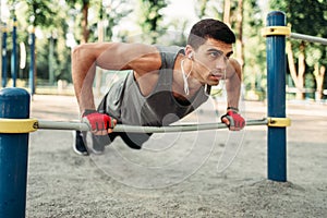 Man doing push-up exercise using horizontal bar