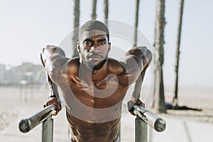 Man doing push ups on bars