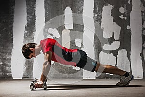 Man doing push ups on dumbbells the wall backdrop