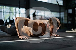 Man doing push ups in a gym. Exhaling and inhaling after push-ups and exercise. Perfect for fitness and workout. Young sports man