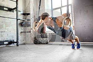 Man doing push-ups on gymnastic rings in gym