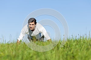 Man doing push ups in summer grass