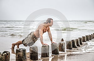 Man doing pushups on the beach