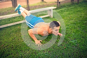 Man doing pushups in park, bodybuilding and training. Fitness concept with shirtless man outdoors, doing exercises