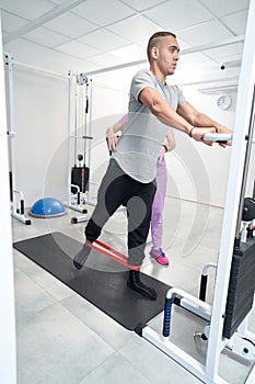 Man doing rehabilitation physiotherapy exercise with fitness rope