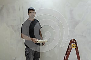 Man doing repairs, finishing room, plasterers, puttied and painted walls photo
