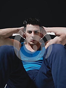 Man doing series of sit-ups on black background