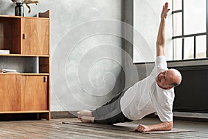 Man doing a side plank exercise at living room.