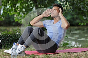 Man doing sit-ups in forest