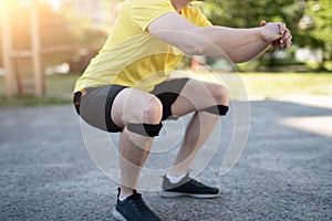 Man doing squat in knee support bandage