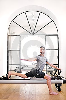 Man doing a standing pilates lunge stretch