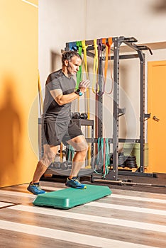 Man doing step up jumps in health club