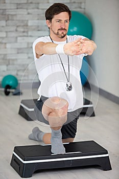 man doing step up jumps in health club