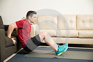 Man doing tricep dips using a couch at home