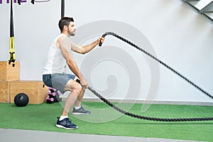 Man Doing Workout With Battle Ropes At Gym