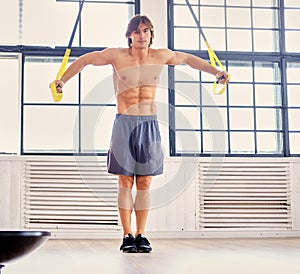 A man doing workouts with suspension trx straps.